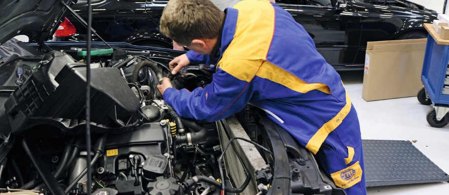 Technician replacing faulty car air con compressor